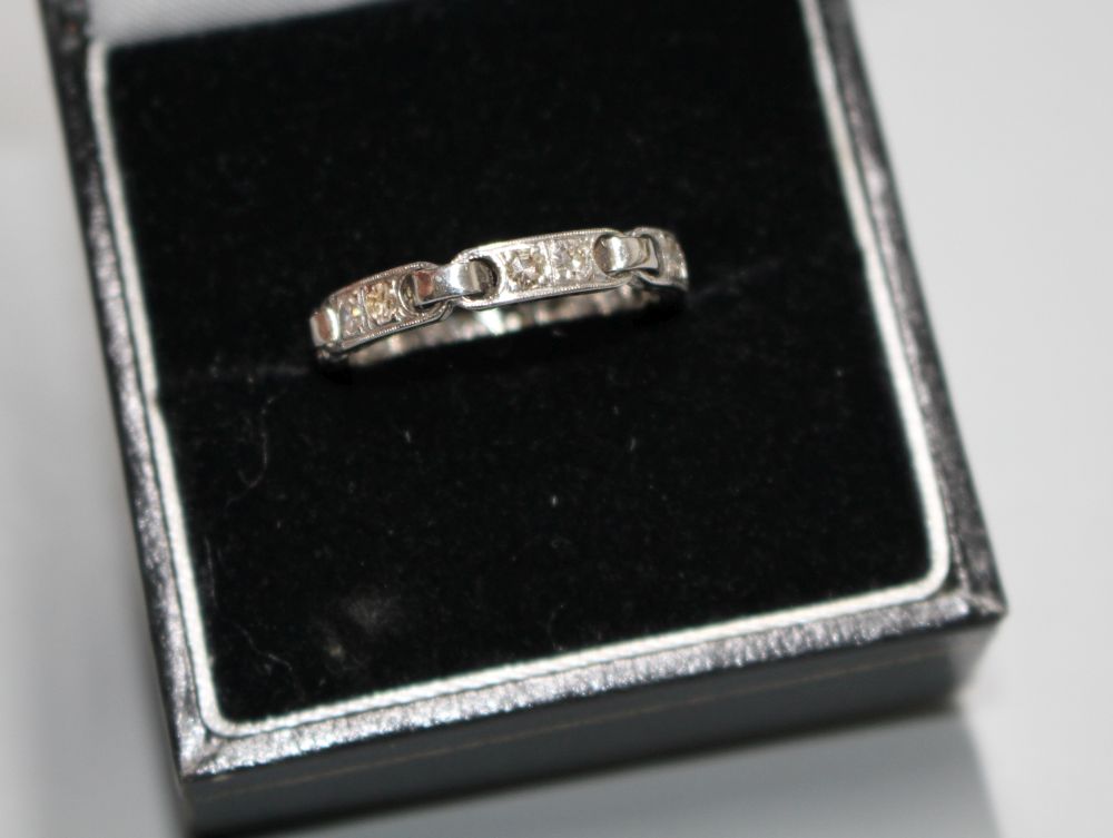 An unusual white metal (stamped Plat) and twelve stone diamond set eternity ring,